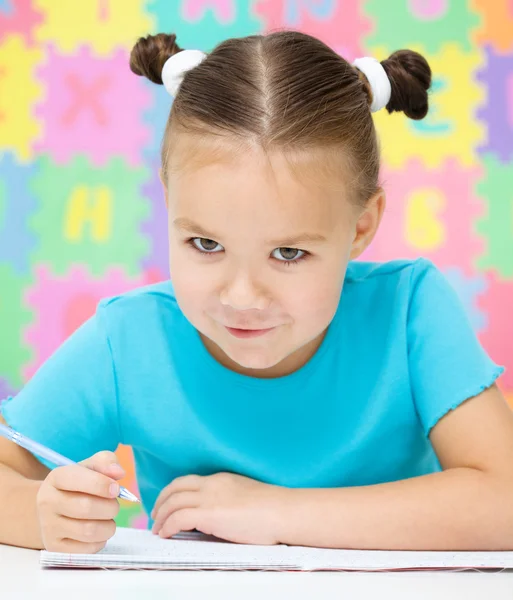 La niña está escribiendo usando un bolígrafo —  Fotos de Stock