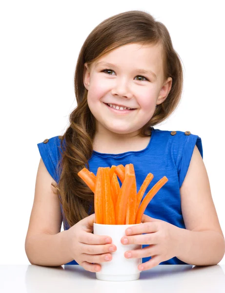 Cute little girl is eating carrot — Stock Photo, Image