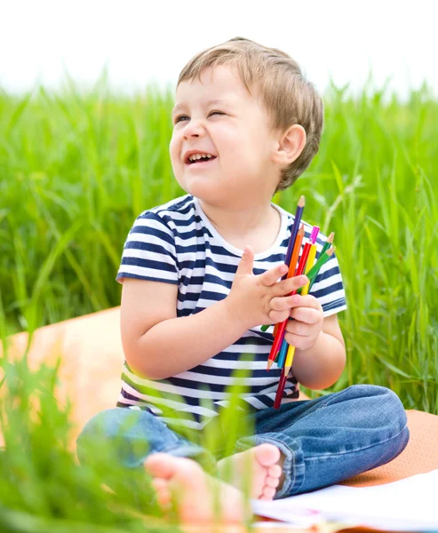 O menino está brincando com lápis. — Fotografia de Stock