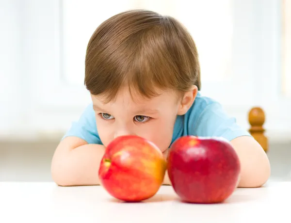 Porträtt av en ledsen liten pojke med äpplen — Stockfoto