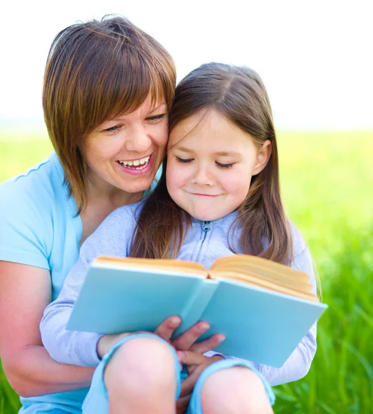 Moeder is het lezen van boek met haar dochter — Stockfoto