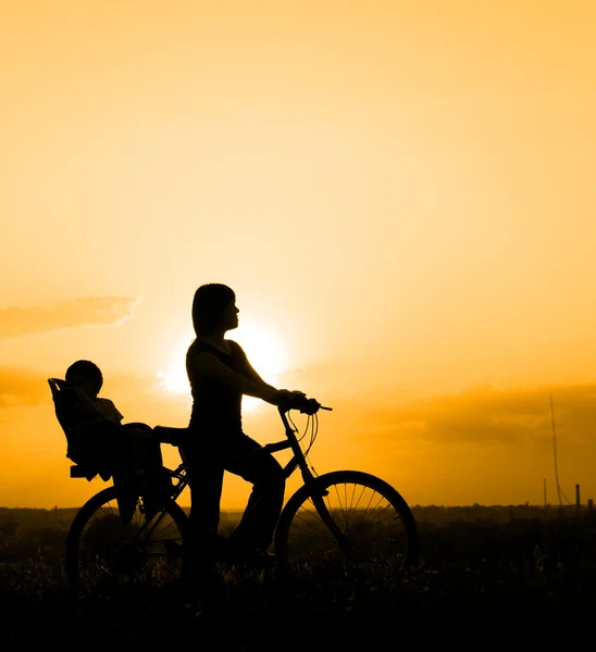 Mother riding on a bicycle with her child — Stock Photo, Image