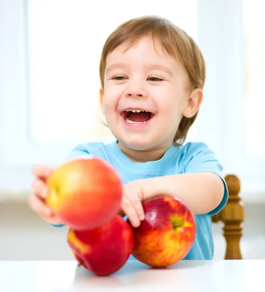 Porträtt av en glad liten pojke med äpplen — Stockfoto