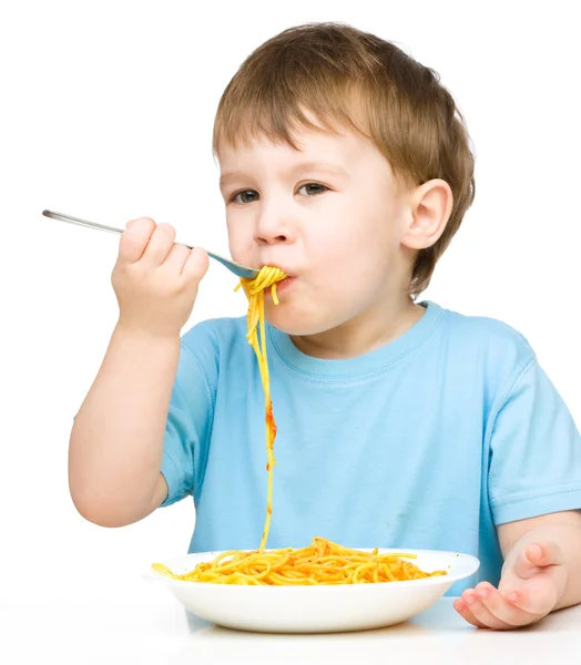 Menino está comendo espaguete — Fotografia de Stock