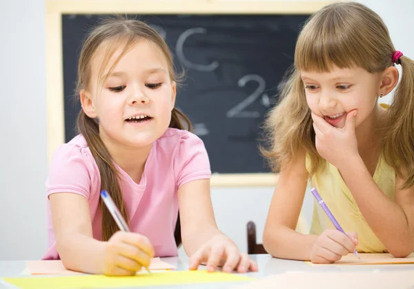 小さな女の子は、ペンを使用して書いています。 — ストック写真