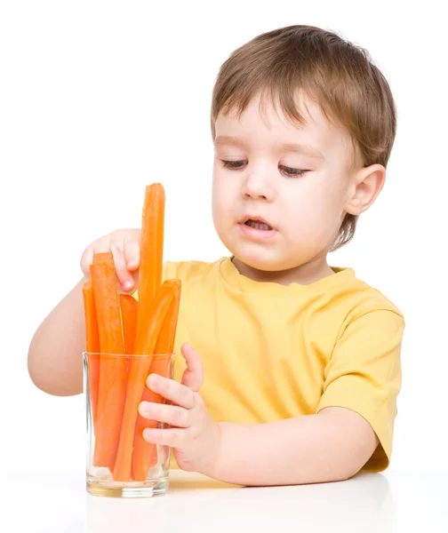 Little boy is eating carrot — Stock Photo, Image