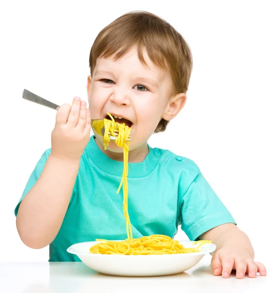 Menino está comendo espaguete — Fotografia de Stock