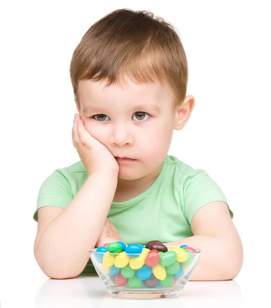 Portrait of a sad little boy with candies — Stock Photo, Image