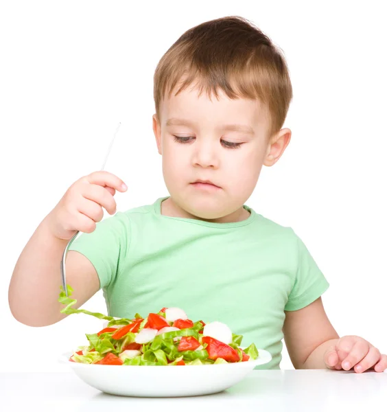 Cute little boy is eating vegetable salad Royalty Free Stock Images