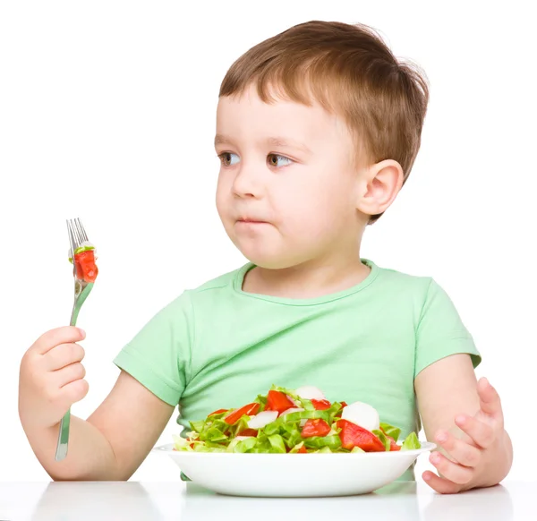 Cute little boy is eating vegetable salad — Stock Photo, Image