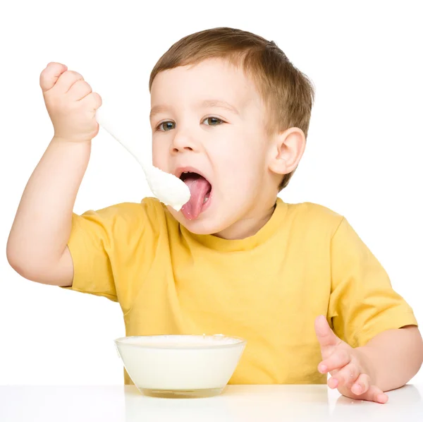 Cute little boy is eating cottage cheese Stock Image