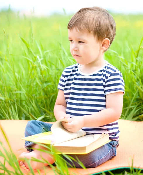 Liten pojke läser bok — Stockfoto