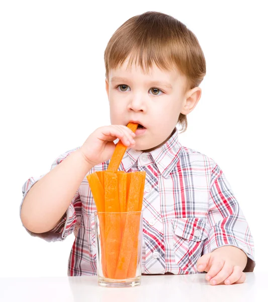 El niño está comiendo zanahoria. —  Fotos de Stock