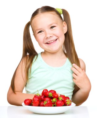 neşeli küçük kız çilek yiyor