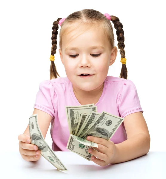 Klein meisje rekent dollar — Stockfoto