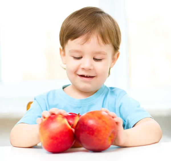 Porträtt av en glad liten pojke med äpplen — Stockfoto