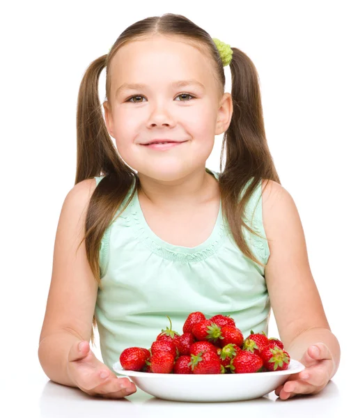 陽気な小さな女の子はイチゴを食べています。 — ストック写真