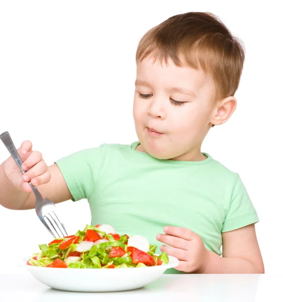 Cute little boy is eating vegetable salad — Stock Photo, Image