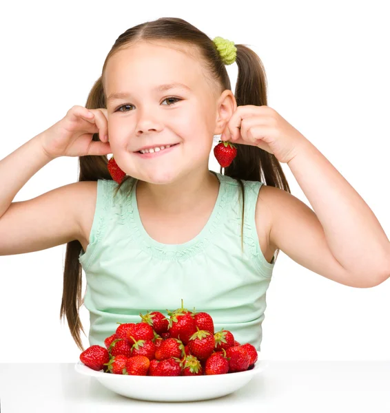 陽気な小さな女の子はイチゴを食べています。 — ストック写真