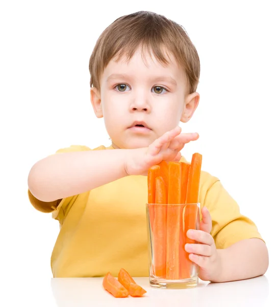 Маленький хлопчик їсть моркву — стокове фото