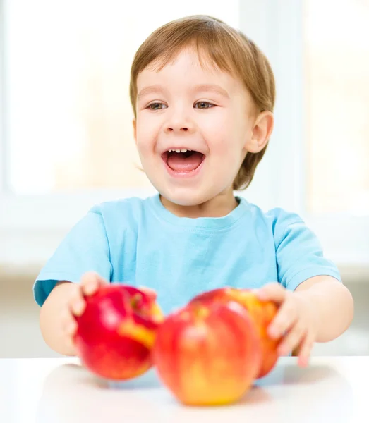 Porträtt av en glad liten pojke med äpplen — Stockfoto