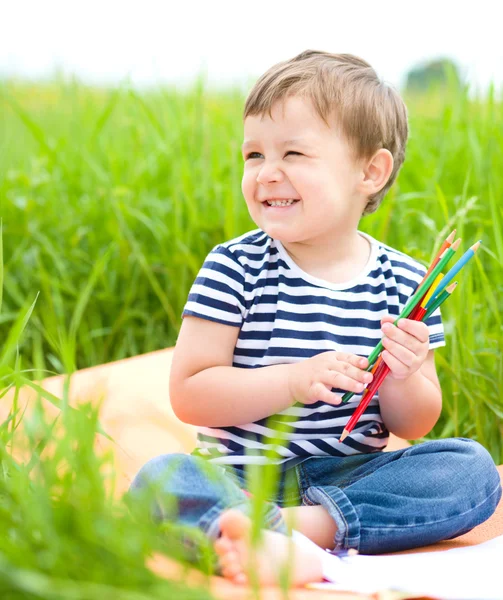 O menino está brincando com lápis. — Fotografia de Stock