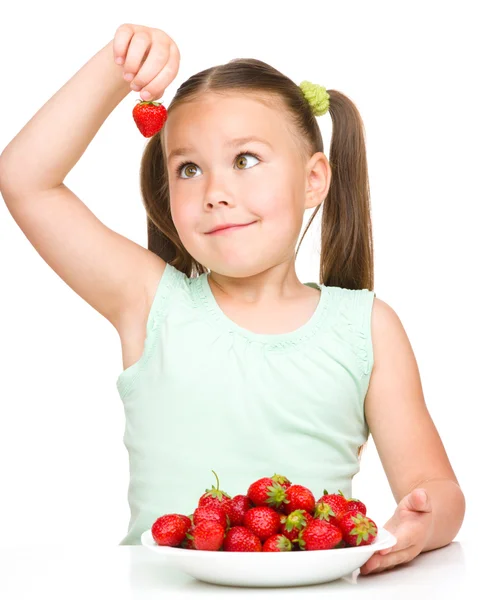 Cheerful little girl is eating strawberries — Stock Photo, Image