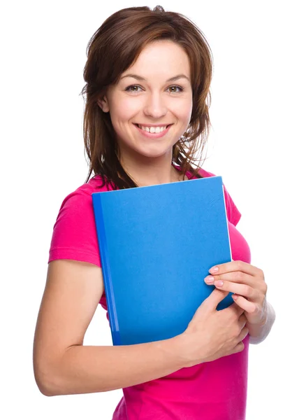 Joven flaco estudiante chica está sosteniendo libro de ejercicios — Foto de Stock