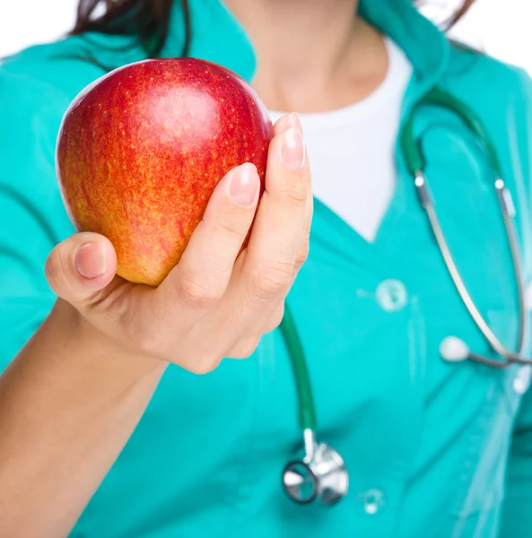 Mladá paní doktorka je drží červené jablko — Stock fotografie