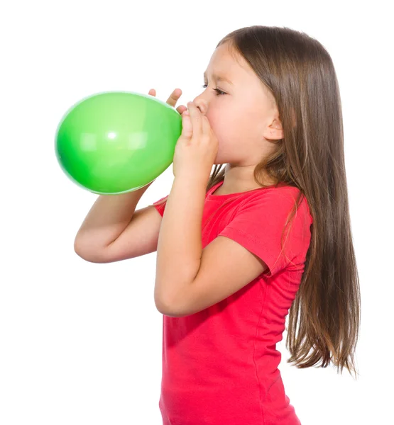 Ragazzina sta gonfiando palloncino verde — Foto Stock