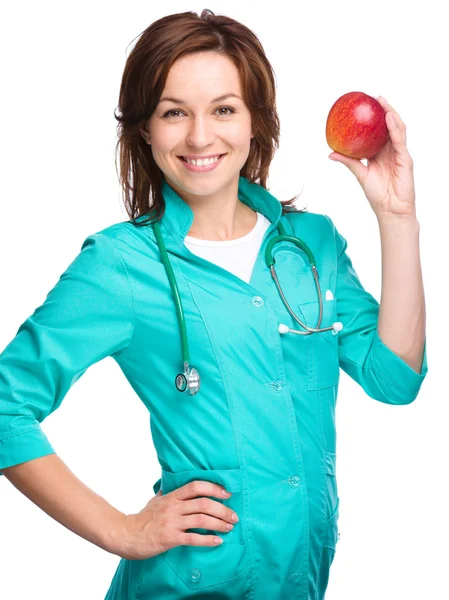 Jeune femme médecin tient une pomme rouge — Photo