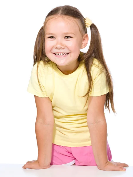 Retrato de uma menina feliz apoiada em uma mesa — Fotografia de Stock