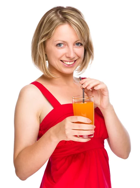 Young woman is drinking carrot juice — Stock Photo, Image