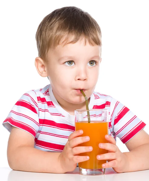 Liten pojke med glas morotsjuice — Stockfoto