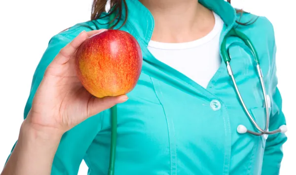 Junge Ärztin hält einen roten Apfel — Stockfoto