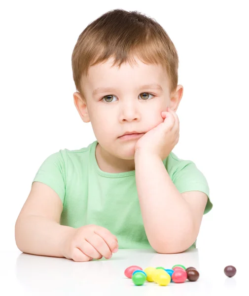 Portrait of a sad little boy with candies — Stock Photo, Image