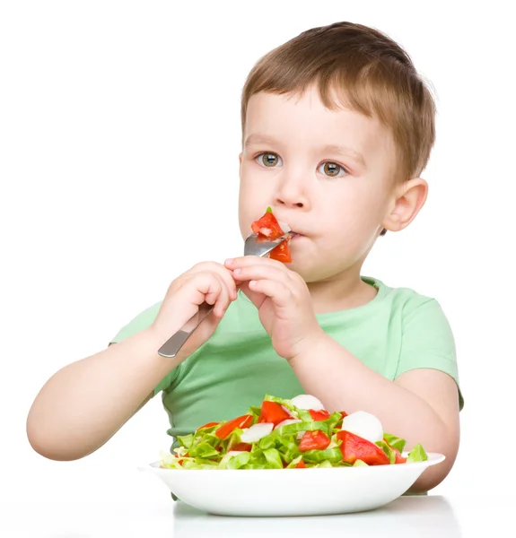 Cute little boy is eating vegetable salad — Stock Photo, Image