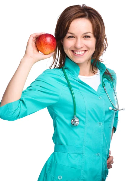 Jeune femme médecin tient une pomme rouge — Photo