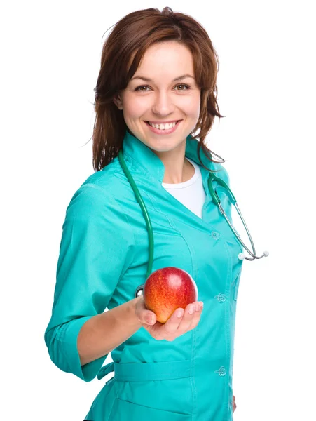 Young lady doctor is holding a red apple Royalty Free Stock Photos