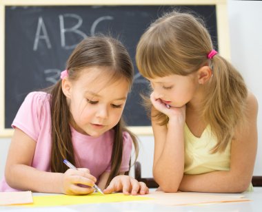 küçük kızlar bir kalem kullanarak yazma