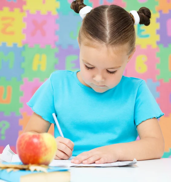 La bambina sta scrivendo usando una penna — Foto Stock