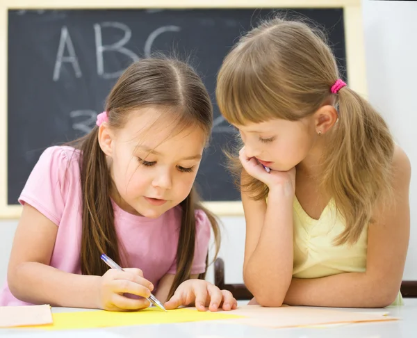 小さな女の子は、ペンを使用して書いています。 — ストック写真