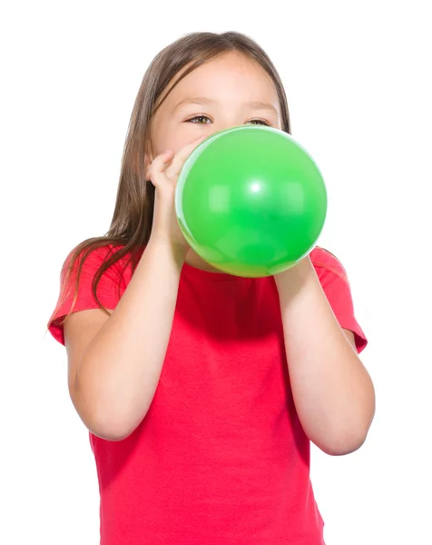 Kleines Mädchen bläst grünen Luftballon auf — Stockfoto