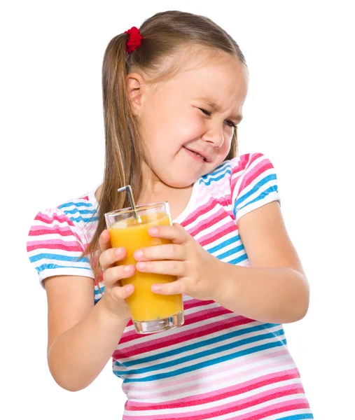 Liten flicka motvilligt dricka apelsinjuice — Stockfoto