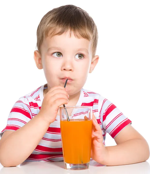 Niño con un vaso de jugo de zanahoria — Foto de Stock