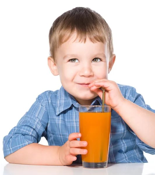 Menino com copo de suco de cenoura — Fotografia de Stock