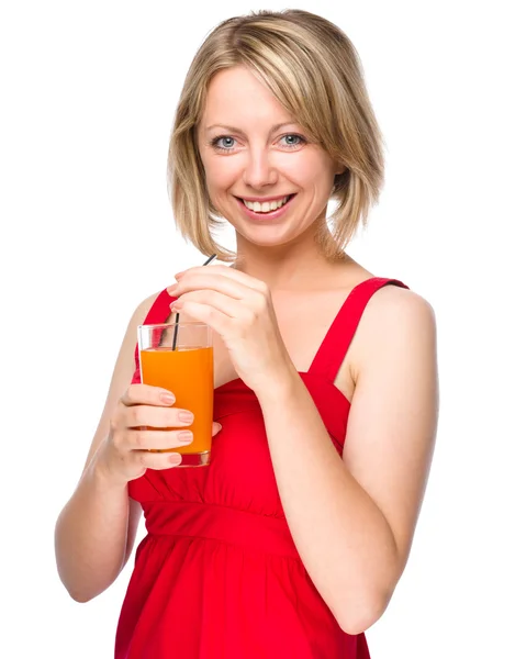 Young woman is drinking carrot juice — Stock Photo, Image