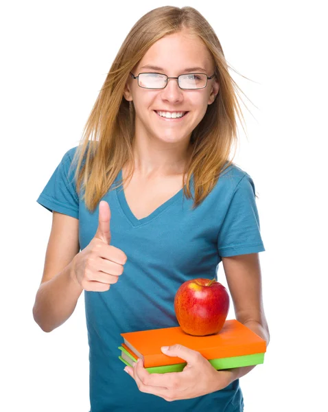 Joven estudiante chica está sosteniendo libro y manzana — Foto de Stock