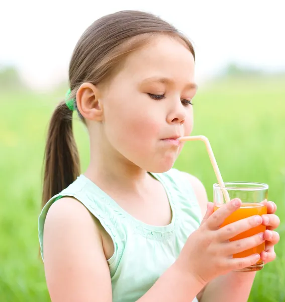 小さな女の子はオレンジ ジュースを飲んでいます。 — ストック写真