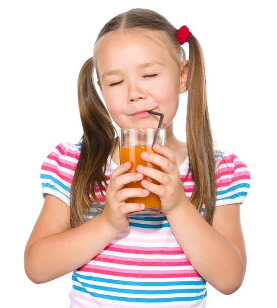 Little girl is drinking carrot juice — Stock Photo, Image